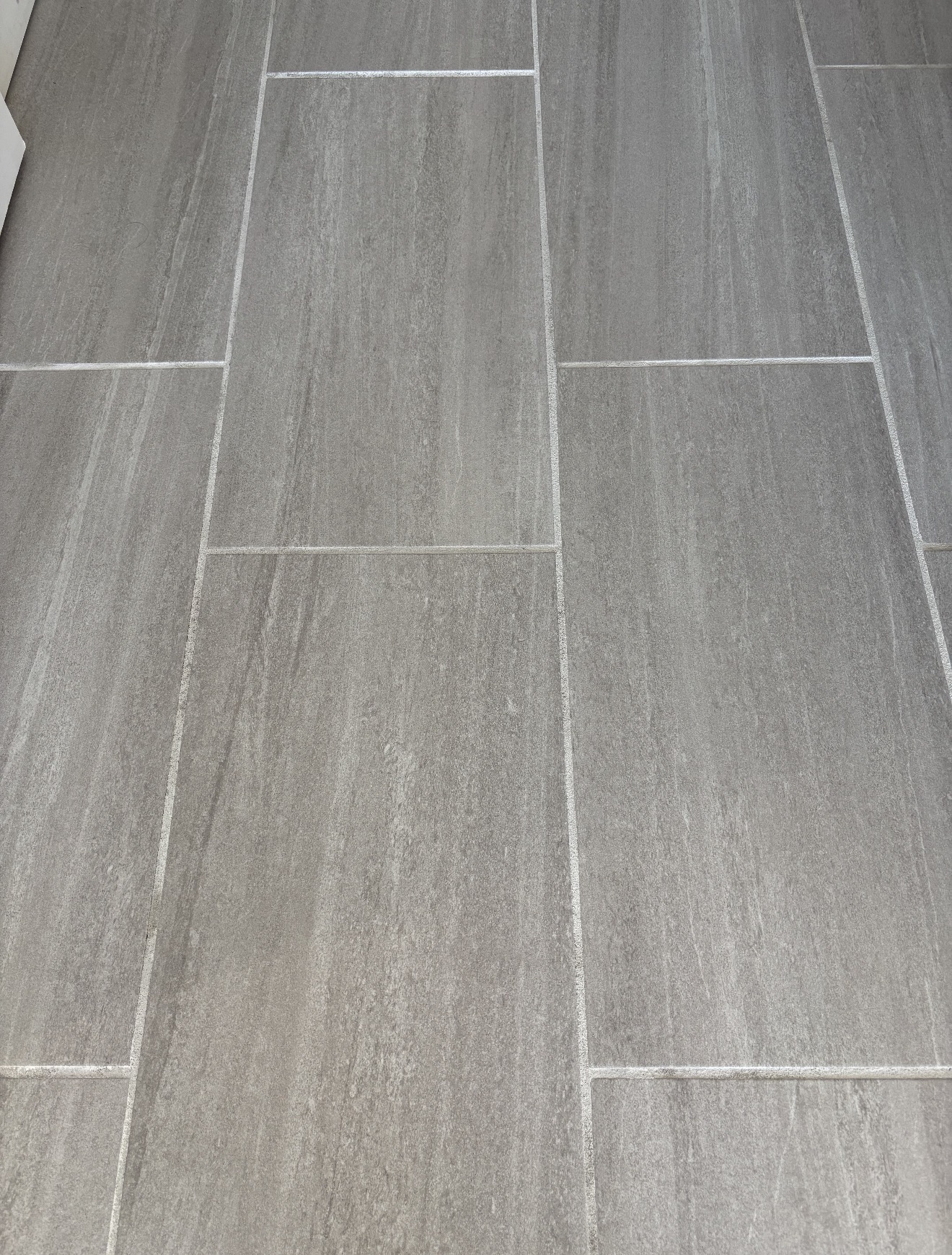 Grey floor tile with bright, clean grout lines