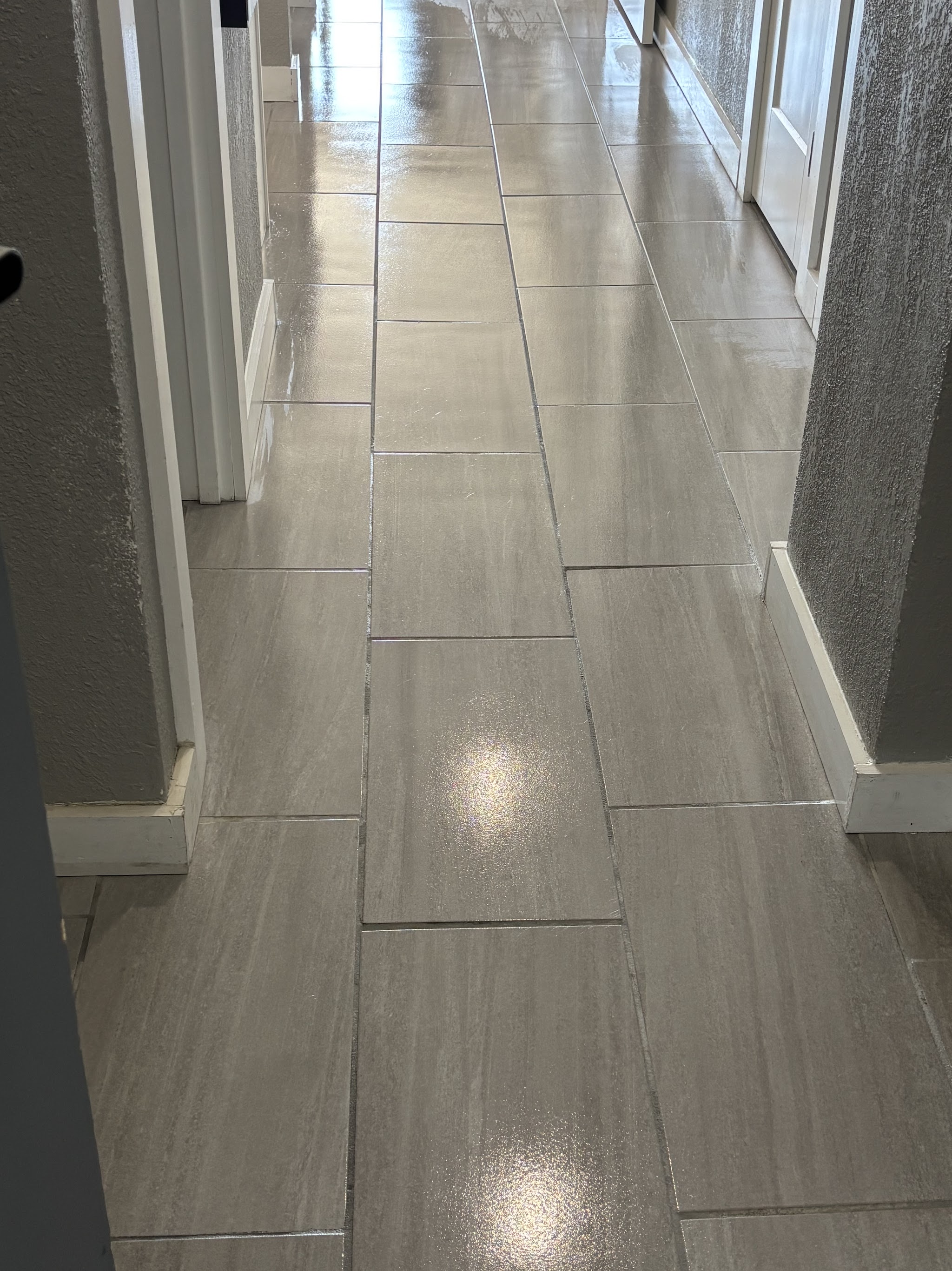 A freshly cleaned tile hallway with gleaming floor
